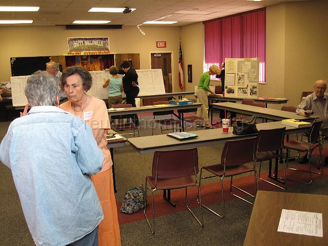 reubinthompson_org_07.jpg - Some of the cousins socializing before the start of the meeting. A four generation decendent chart of Reubin Thompson is located in the background.