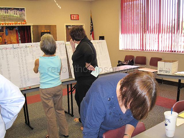 reubinthompson_org_09.jpg - Cousins checking the genealogy chart of Reubin Thompson showing the first four generations.